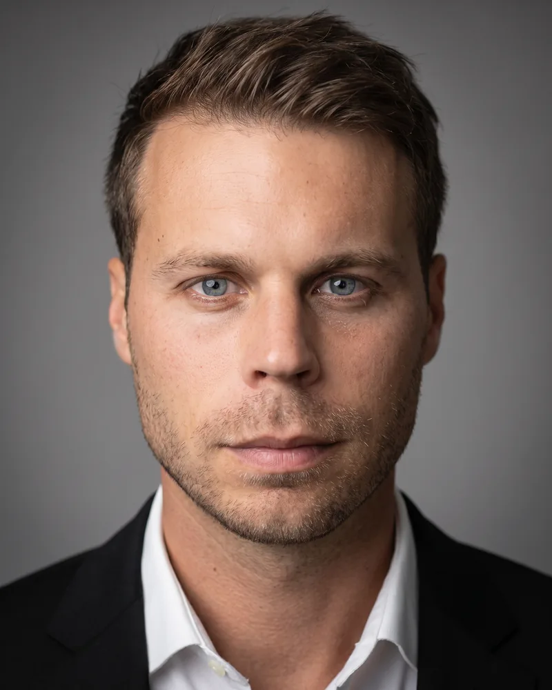 Professional headshot example generated by Staffshots — attire option: Black suit
