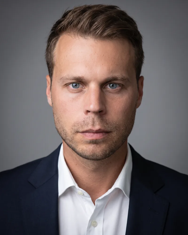 Professional headshot example generated by Staffshots — attire option: Dark jacket, plain shirt