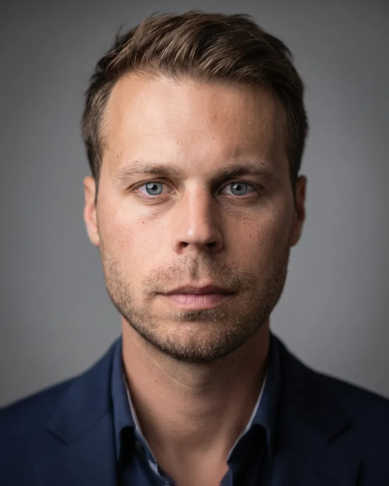 Professional headshot example generated by Staffshots — attire option: Navy blazer, open collar